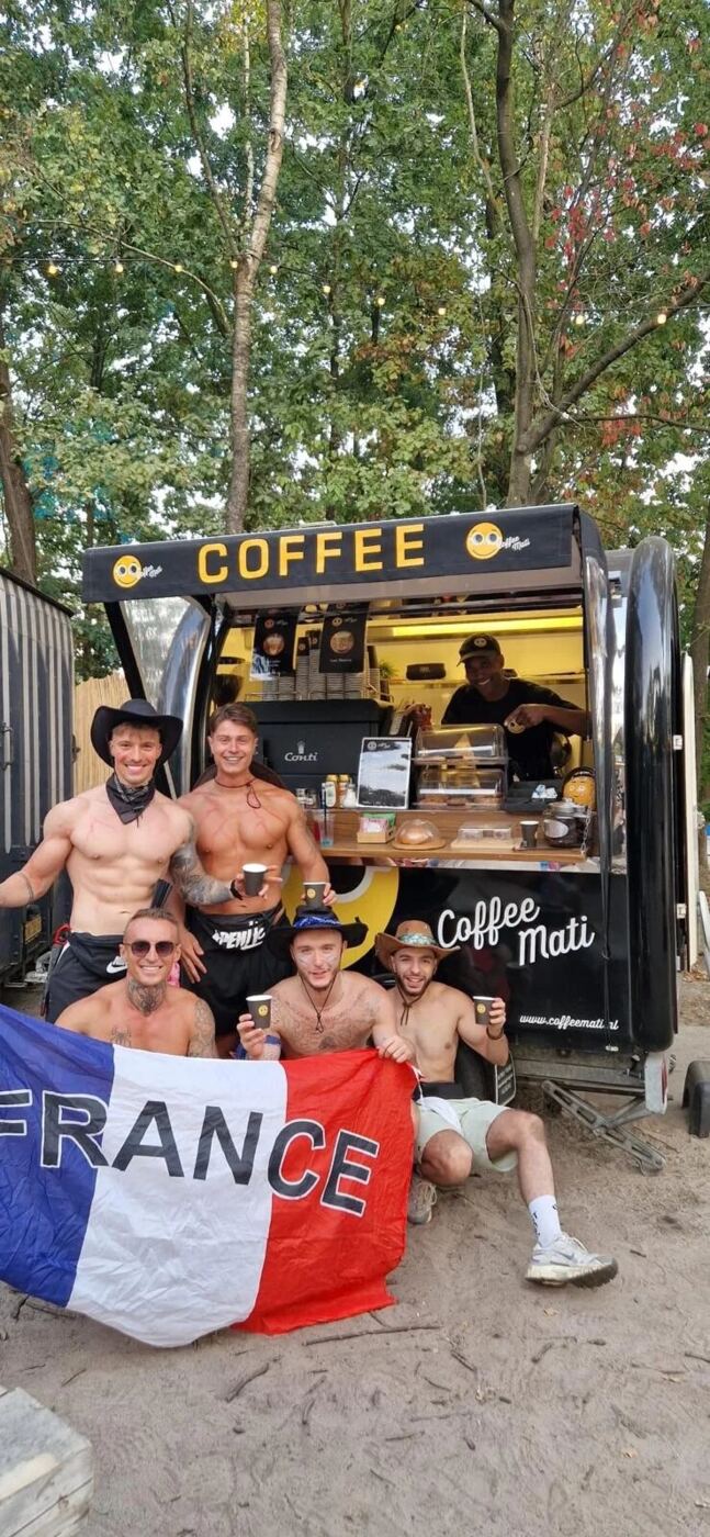 Feestvierende gasten met een Franse vlag bij de truck op een festival