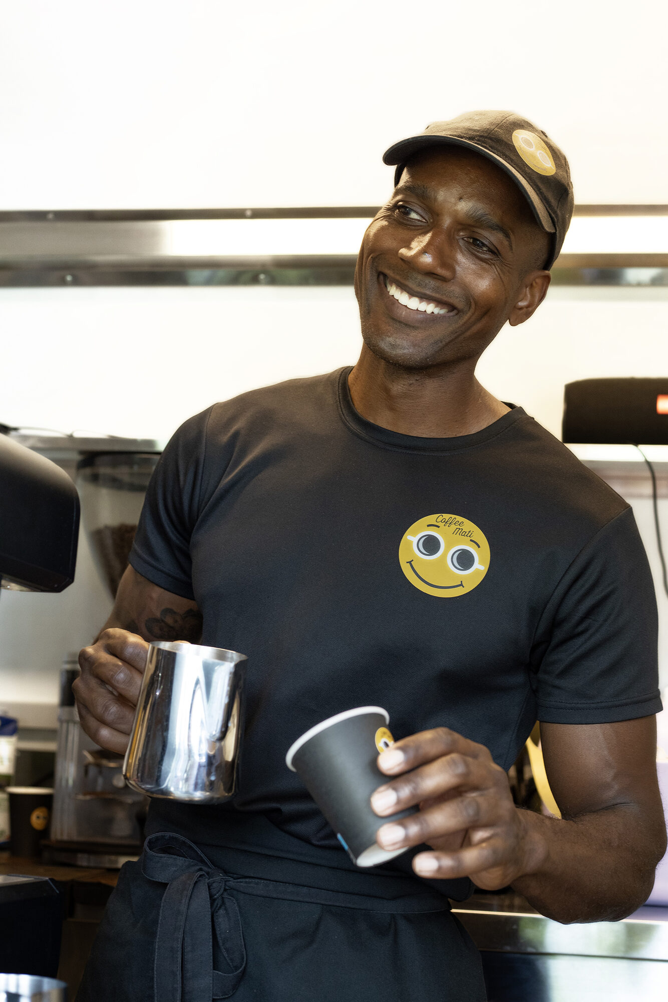Jerry lachend achter de toonbank van Coffee Mati